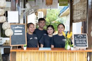 a group of people standing behind a counter at Trisha Guesthouse in San Vicente