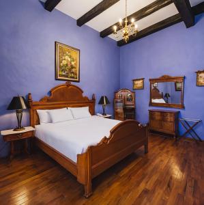 a bedroom with a large bed and blue walls at La Casa de la Marquesa in Querétaro +33 photos