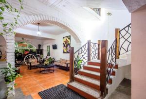 a living room with a staircase in a house at Hotel Hacienda de Vallarta Centro in Puerto Vallarta