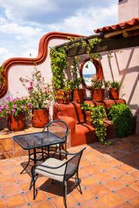 a patio with a table and chairs and potted plants at La Casa de la Marquesa in Querétaro