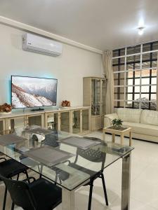 a living room with a glass table and a tv at Alojamiento Jaén in Jaén