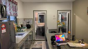 a kitchen with a desk with a laptop on it at The Retreat Homestay in Tanjung Malim +15 photos