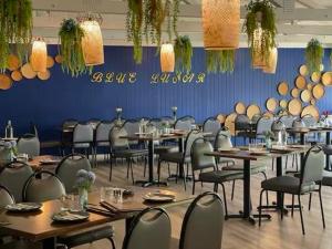 a dining room with tables and chairs and a blue wall at The Select Inn Gosford in Gosford +128 photos