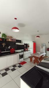 a kitchen with white cabinets and a table in it at Casa LuPi in Carmo do Rio Claro