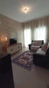 a living room with two couches and a tv at Casa LuPi in Carmo do Rio Claro