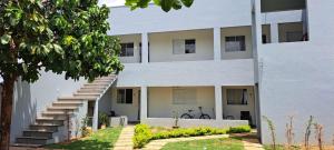 a white building with stairs on the side of it at Apto Cozi in Sorriso