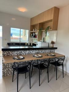 a kitchen with a wooden table and two chairs at Apto Mais Decor in Salinas