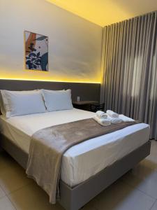 a bedroom with a bed with two towels on it at Apto Mais Decor in Salinas