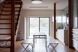 a kitchen and dining room with a table and stairs at Kaitan雲津 in Matsue