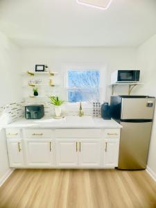 a kitchen with white cabinets and a refrigerator at The Blue House in Dover