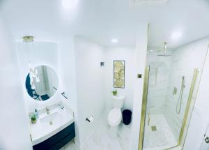a white bathroom with a toilet and a shower at The Blue House in Dover