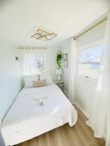 a bedroom with a large white bed with a window at The Blue House in Dover