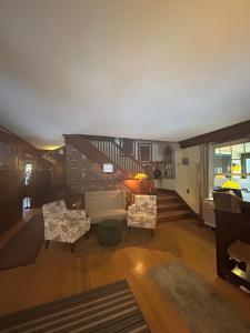 a living room with a couch and chairs and a staircase at Oxford House Inn in Fryeburg
