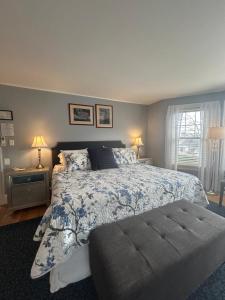 a bedroom with a bed with a blue and white comforter at Oxford House Inn in Fryeburg