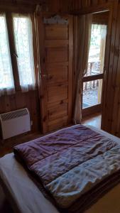 a bedroom with a bed in a room with windows at Camping La Motte Flottante in La Freissinouse
