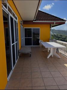 a patio with a white bench on a house at Vue d'Ô in Taputapuapea