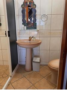 a bathroom with a sink and a toilet at Vue d'Ô in Taputapuapea