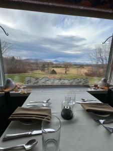 a table with a view of a field from a window at Oxford House Inn in Fryeburg