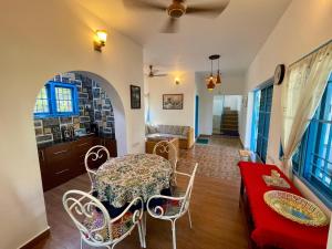 a living room with a table and chairs and a couch at La Maison Bougainvillea in Mahabalipuram +33 photos