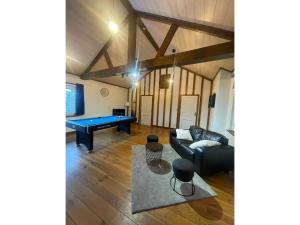 a living room with a couch and a pool table at Modern Chalet in Sougné-Remouchamps near Forest in Aywaille