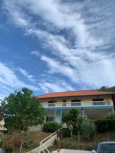 a building with an orange roof and a cloudy sky at Scan House Apartment in Karon Beach