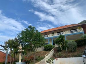 a house on a hill with stairs and trees at Scan House Apartment in Karon Beach