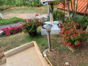 a street light in a garden with flowers at Scan House Apartment in Karon Beach