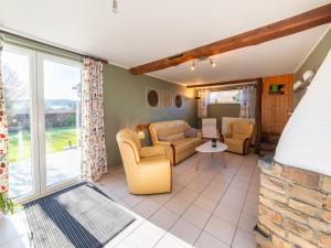 ein Wohnzimmer mit Sofa, Sesseln und einem Fenster in der Unterkunft Modern Holiday Home in Lavacherie in Sainte-Ode