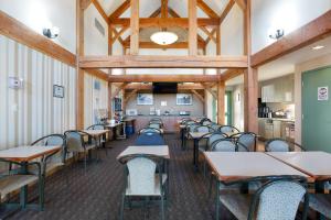 a dining room with tables and chairs and a ceiling at Lakeview Inns & Suites - Okotoks in Okotoks
