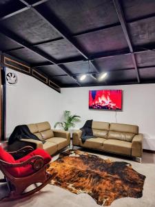 a living room with a couch and a chair at Domo Fengari in Pululahua