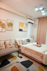 a living room with a bed and a couch at Gold-Themed Condo with Balcony and FREE Pool Access in Suba +19 photos