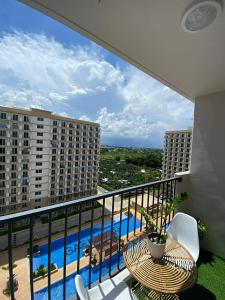 a balcony with a table and chairs and a pool at Gold-Themed Condo with Balcony and FREE Pool Access in Suba