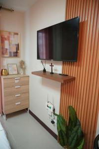 a living room with a flat screen tv on a wall at Gold-Themed Condo with Balcony and FREE Pool Access in Suba