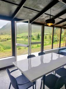 a white table and chairs in a room with windows at Domo Fengari in Pululahua