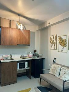 a kitchen with a counter and a couch in a room at Gold-Themed Condo with Balcony and FREE Pool Access in Suba