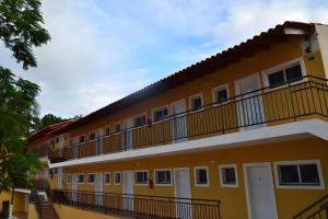 a large yellow building with a balcony at Hotel Portal do Eden in Sorocaba