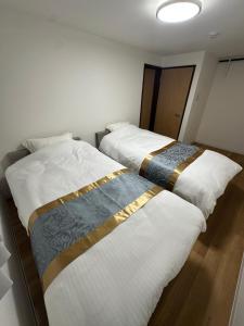 two beds sitting next to each other in a room at Waen Tenma in Osaka