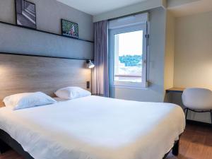 a hotel room with a large bed and a window at Ibis Agen Centre - Rénové en 2026 in Agen