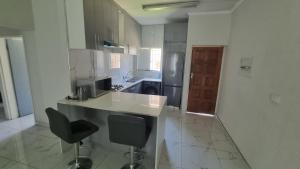 a kitchen with a counter and two chairs in it at 124 On Comet Oaks in Boksburg +14 photos