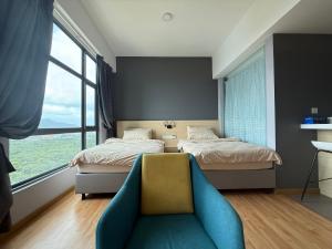 a bedroom with two beds and a blue couch at Swiss Cozy Studio Kuantan City View Imperium Residence in Kuantan +33 photos