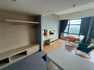 a living room with a table and chairs and a television at Swiss Cozy Studio Kuantan City View Imperium Residence in Kuantan
