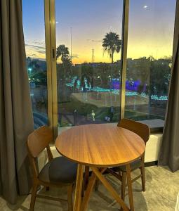 a wooden table and two chairs in front of a window at Balam Suites in Playa del Carmen