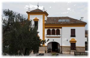 Un edificio con una torre de reloj en la parte superior. en Hostal- Restaurante Estación Vía Verde, en Olvera