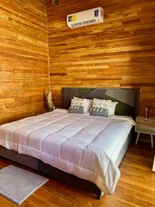 a bedroom with a bed with a wooden wall at Villa Republik in Parrita