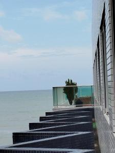 a building with stairs leading to the ocean at Flat Praia Cabo Branco João Pessoa in João Pessoa