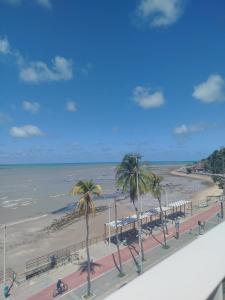 a view of a beach with palm trees and the ocean at Flat Praia Cabo Branco João Pessoa in João Pessoa +1 photo
