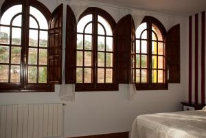 Un dormitorio con ventanas arqueadas y una cama. en Hostal- Restaurante Estación Vía Verde, en Olvera 29 fotos más