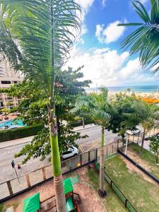a palm tree on a balcony with a view of the ocean at Hotel Platinum - Landscape Luxo - in Fortaleza
