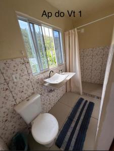 a bathroom with a toilet and a sink and a window at Pouso amigo do Vt 2 in Paracambi +26 photos