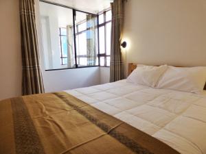 a bedroom with a large bed with a window at Tierra Espiritual - Andean Holistic Hotel in Puno +38 photos
